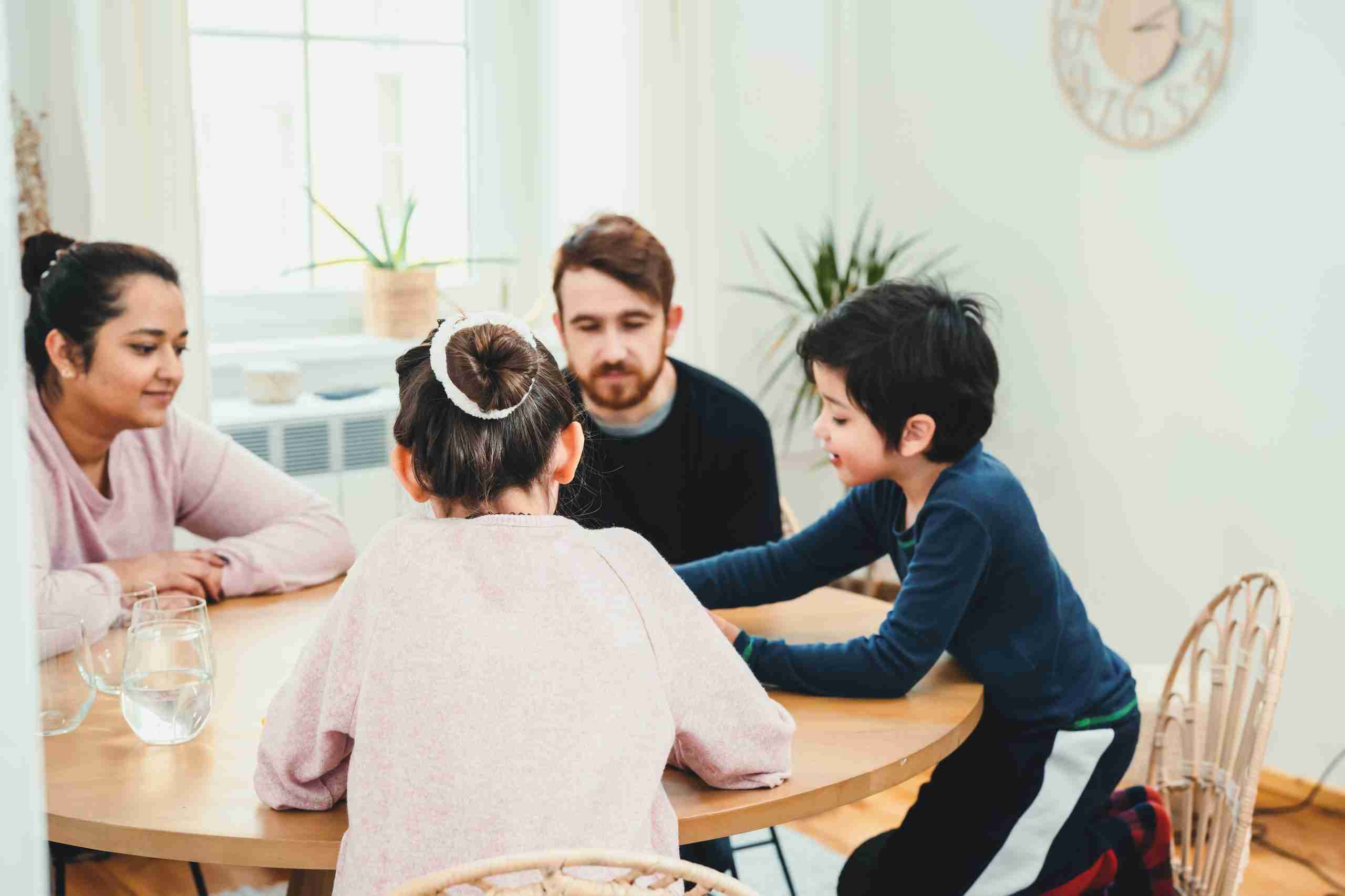 Family playing with board game together at the table