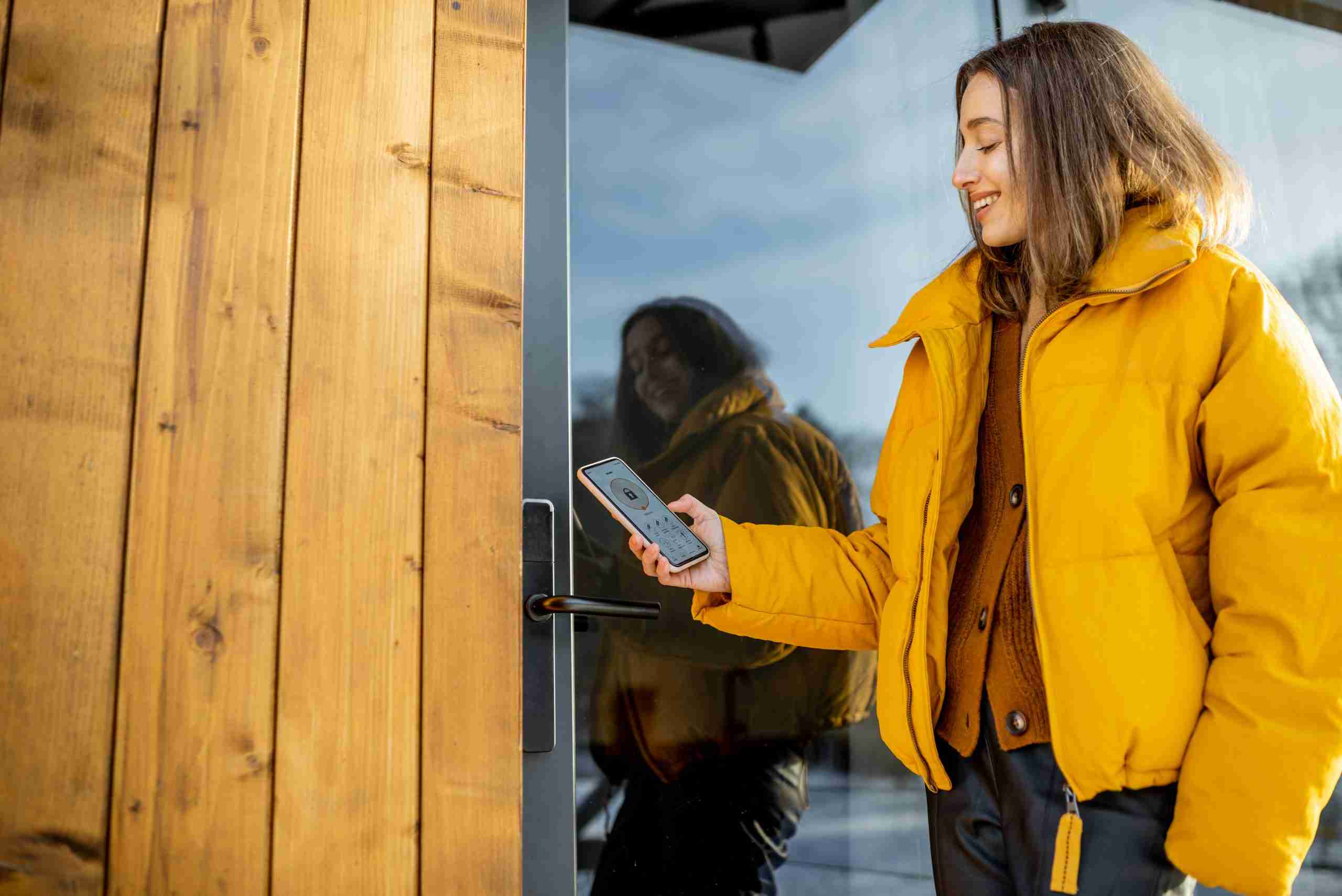 A woman manages her smart lock from her phone